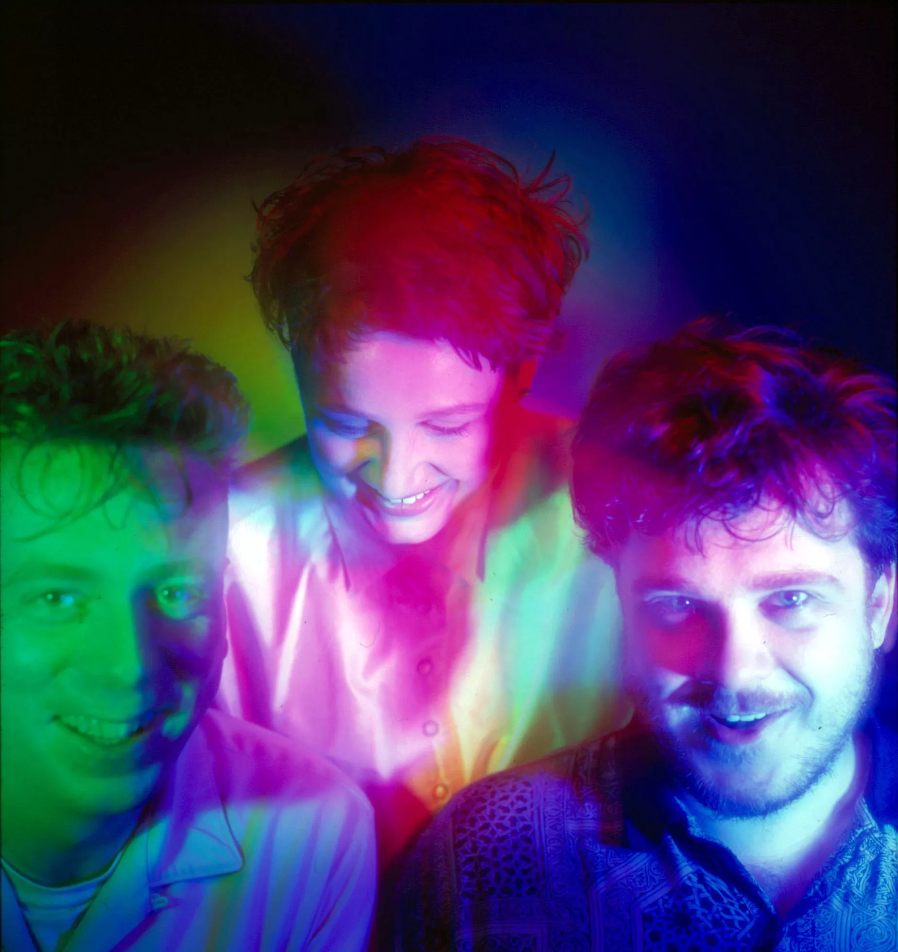 Fra venstre mod højre er personerne: Robin Guthrie (Guitarist), Elizabeth Fraser (Sanger), Simon Raymonde (Bassist og multiinstrumentalist).