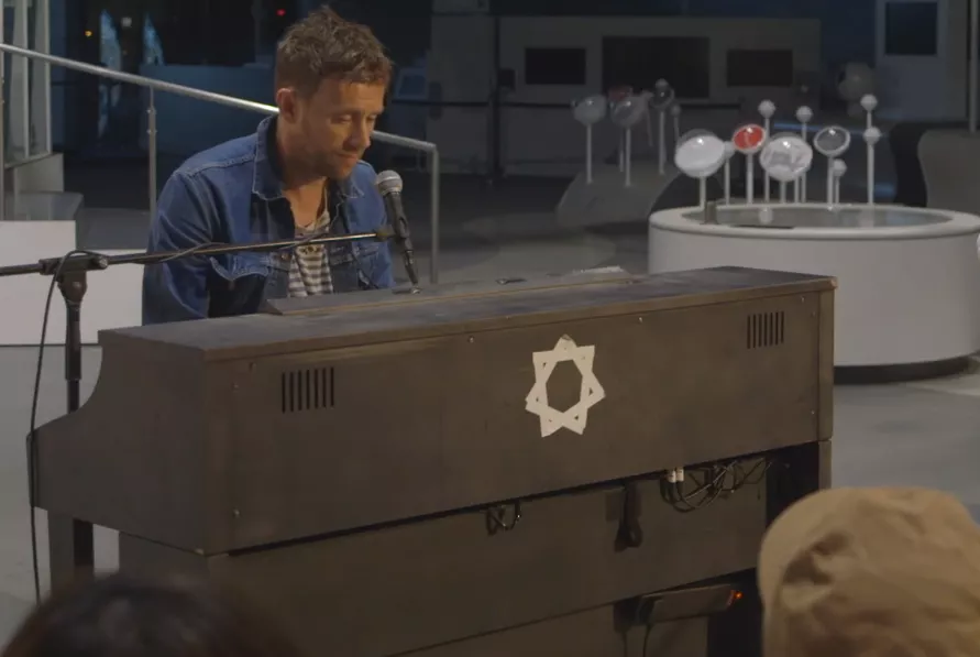 Se Damon Albarn synge for robot