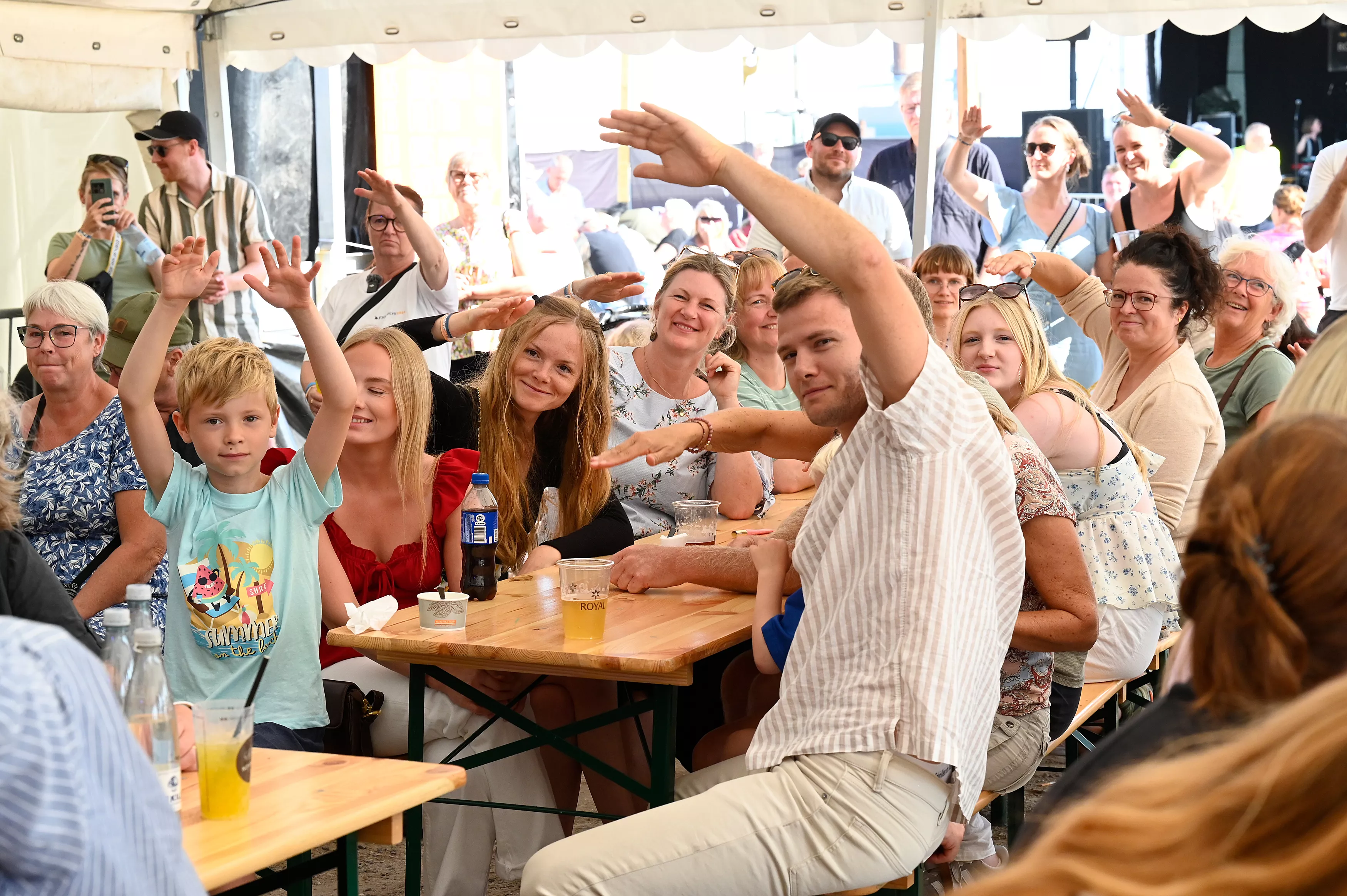 Fra teenagere til bedsteforældre – fællesskabet blomstrede under festteltets dug, hvor musik og sommerstemning samlede generationer om langbordene på Fjordlys Festival 2024. Foto: Peter Dahlerup, Fjordlys Festival ©